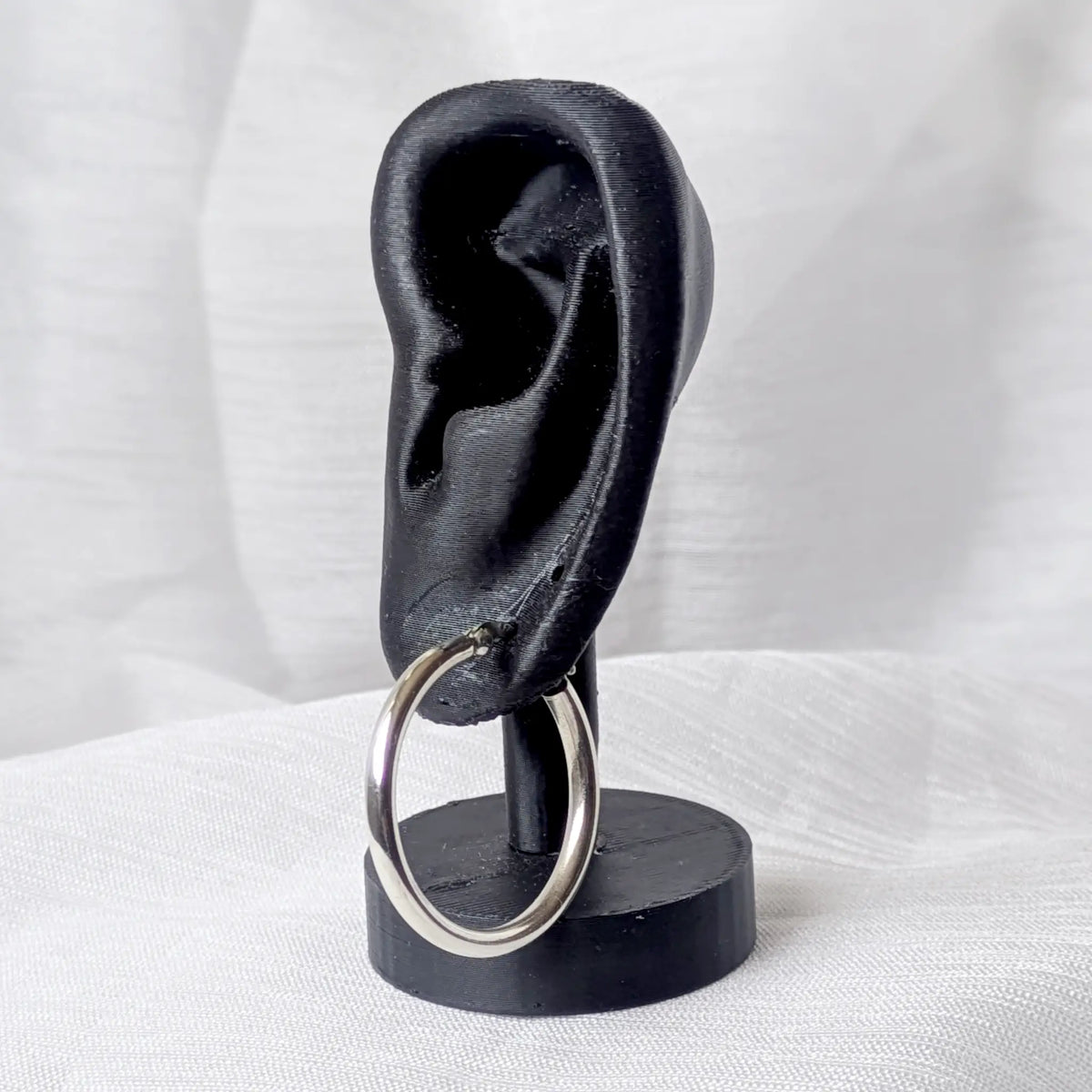 Eine markante, 3mm dicke Silbercreole, Durchmesser 30mm, elegant und auffällig an einem schwarzen 3D-Ohr-Display präsentiert.