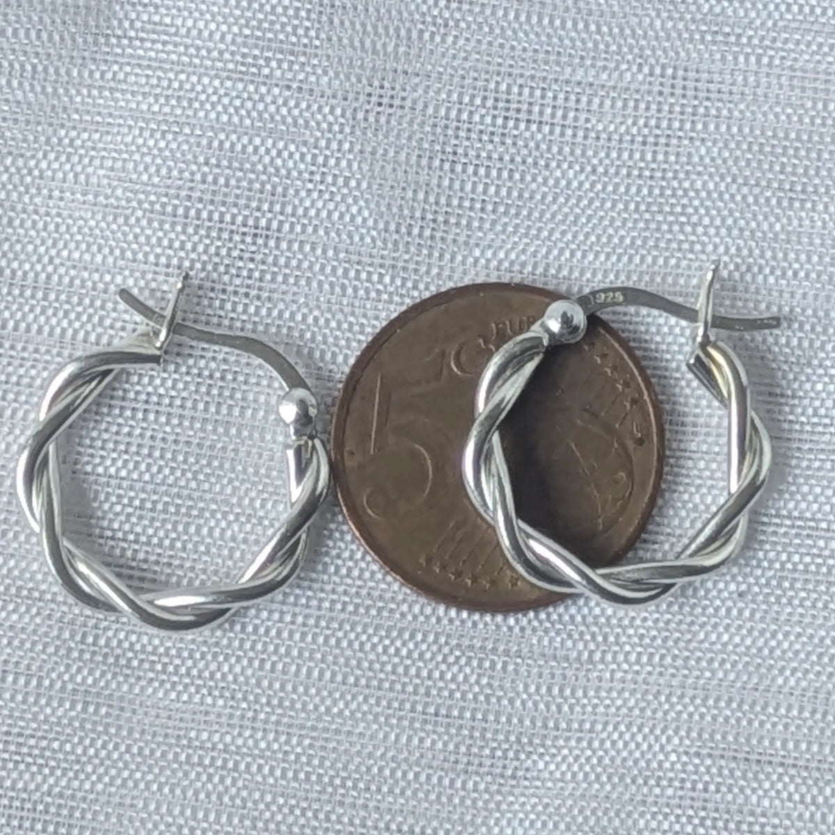 Gedrehte 925 Silber Creolen liegend auf einer 5-Cent-Münze zur genauen optischen Größeneinschätzung.