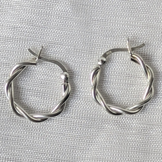 Nahaufnahme von zwei glänzenden 925 Silber Creolen im gedrehten Kordel-Design.