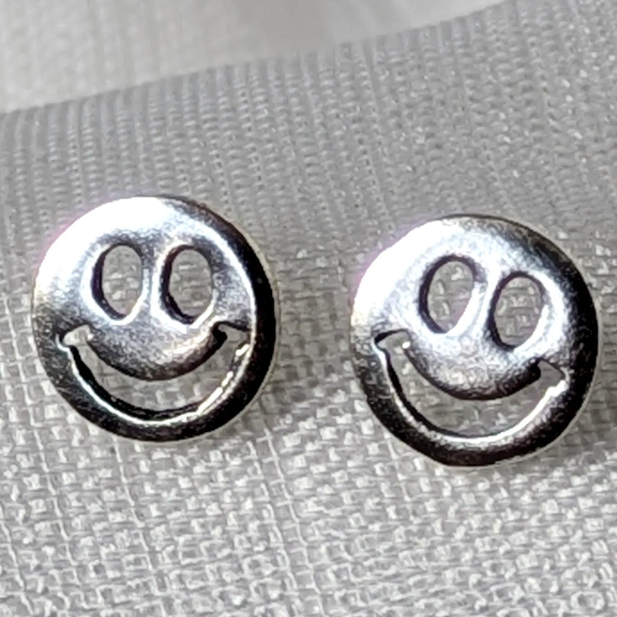 Nahaufnahme von Smiley Ohrsteckern aus glänzend poliertem 925 Sterling Silber