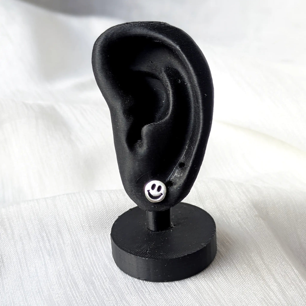 Smiley Ohrstecker 925 Silber getragen am schwarzen Ohr-Display zur Größenansicht