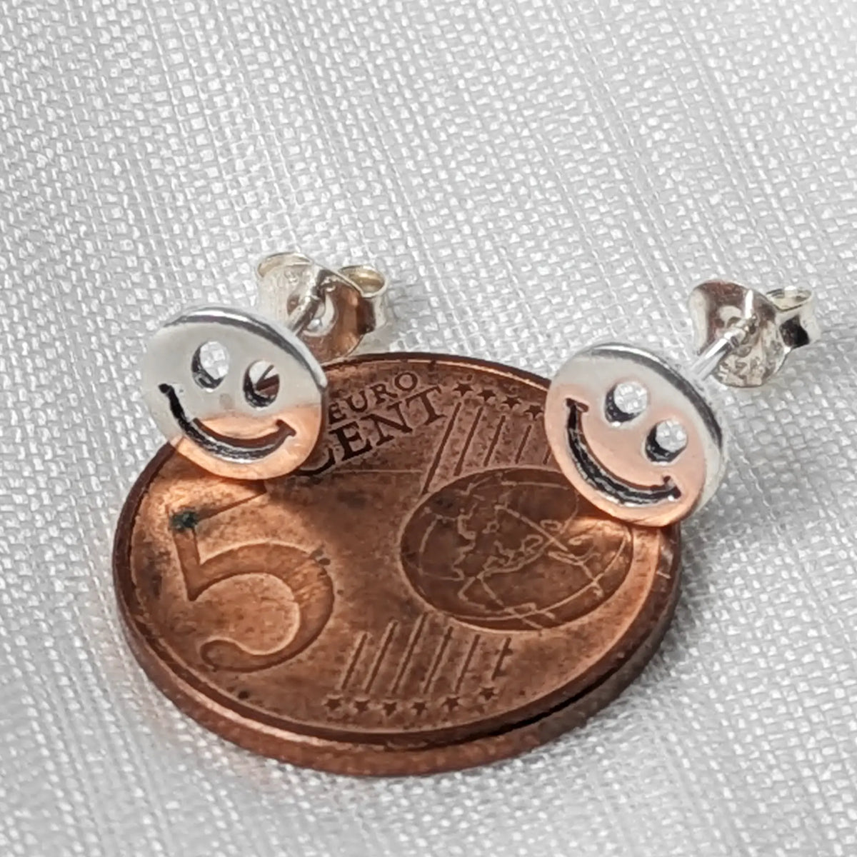 Größenvergleich: Kleiner 925 Silber Smiley Ohrstecker auf einer 5-Cent-Münze
