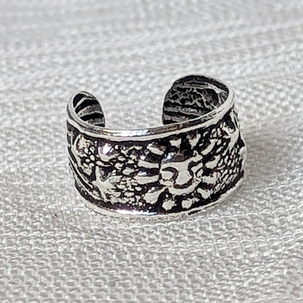 Nahaufnahme eines Ear Cuffs aus 925 Silber mit detailliertem Sonnen- und Sternen-Motiv