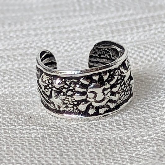 Nahaufnahme eines Ear Cuffs aus 925 Silber mit detailliertem Sonnen- und Sternen-Motiv