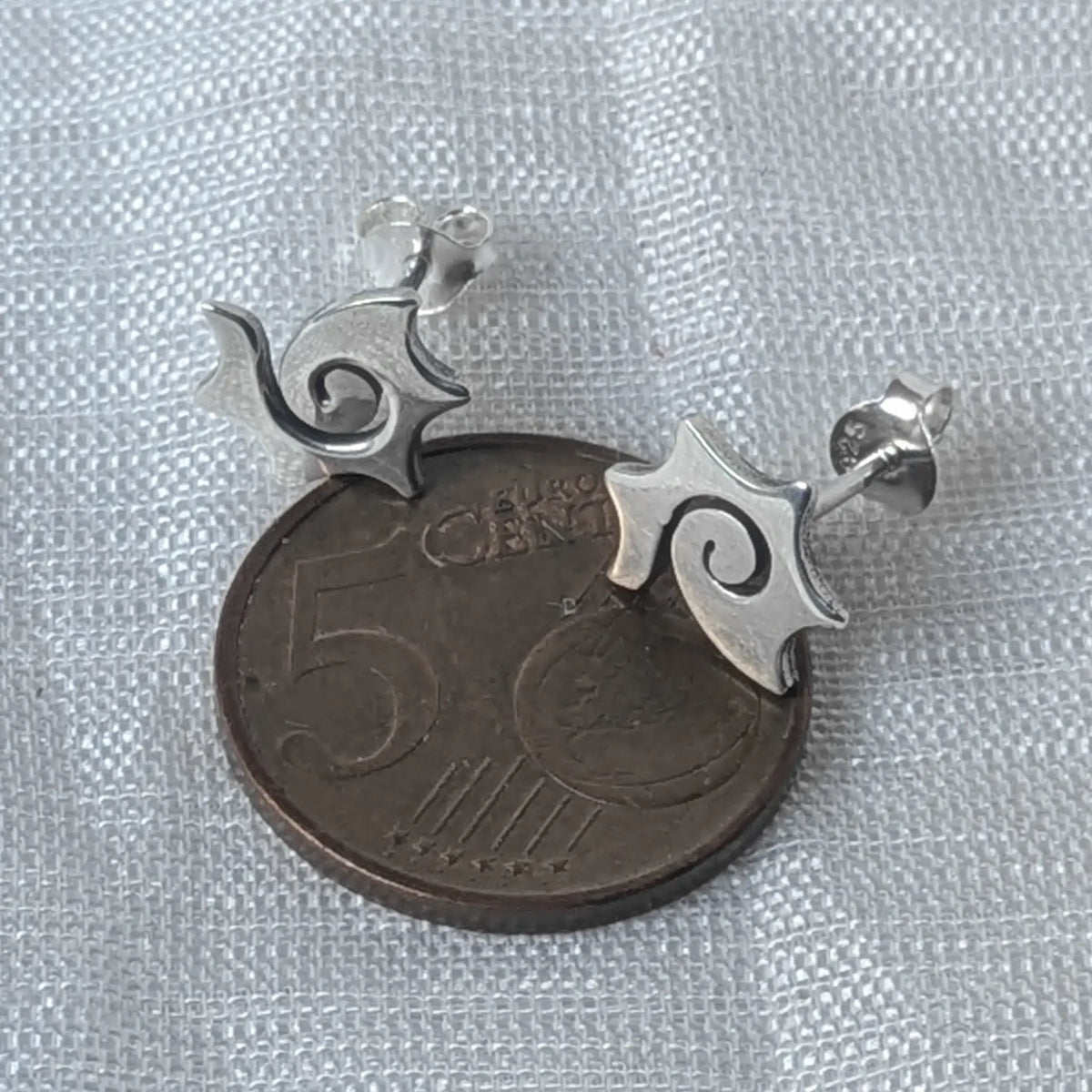 Größenvergleich der zierlichen Spiral-Sonnen-Ohrstecker aus Silber, flach liegend auf einer 5-Cent-Münze.