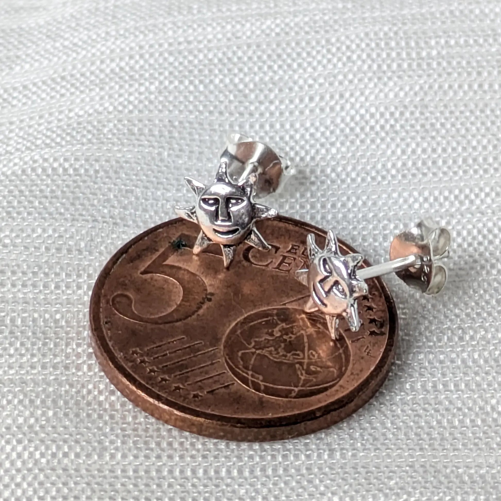 Detailreiches 925 Silber Sonnengesicht Ohrring-Paar platziert auf einer 5-Cent-Euro-Münze als Größenvergleich