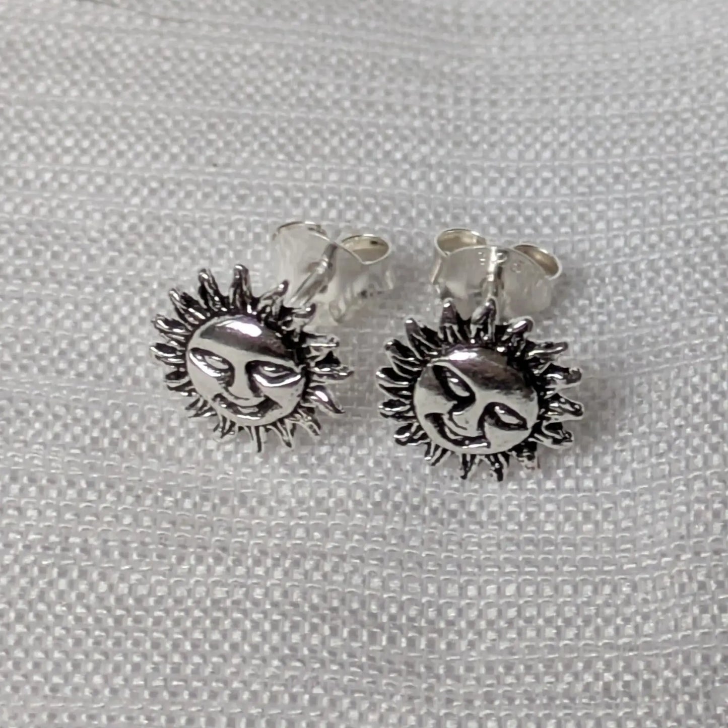 Paar silberne Sonnen-Ohrstecker mit Gesicht in der Vorderansicht.
