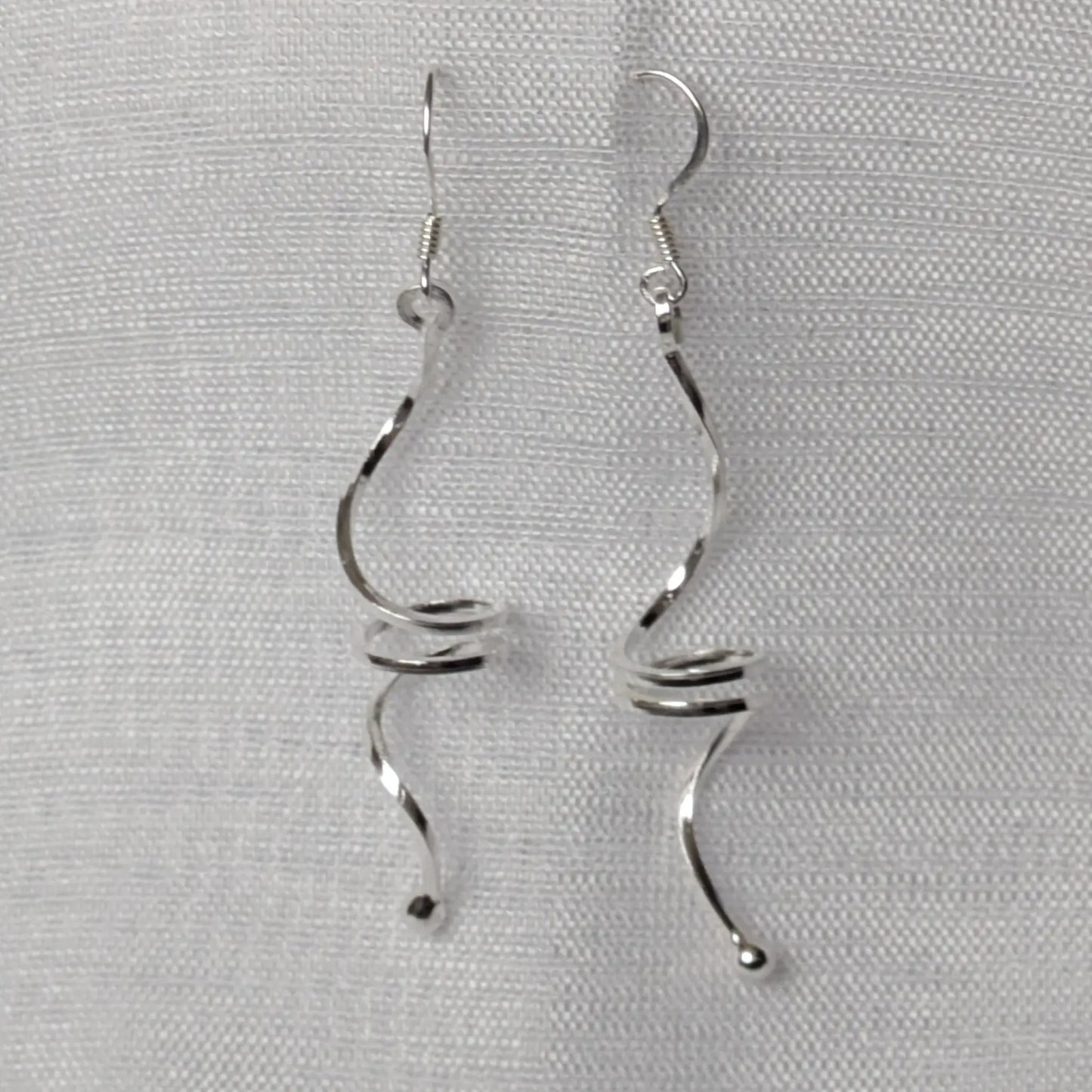 Frontalansicht der langen, geschwungenen Wellen-Ohrringe aus Sterling Silber.