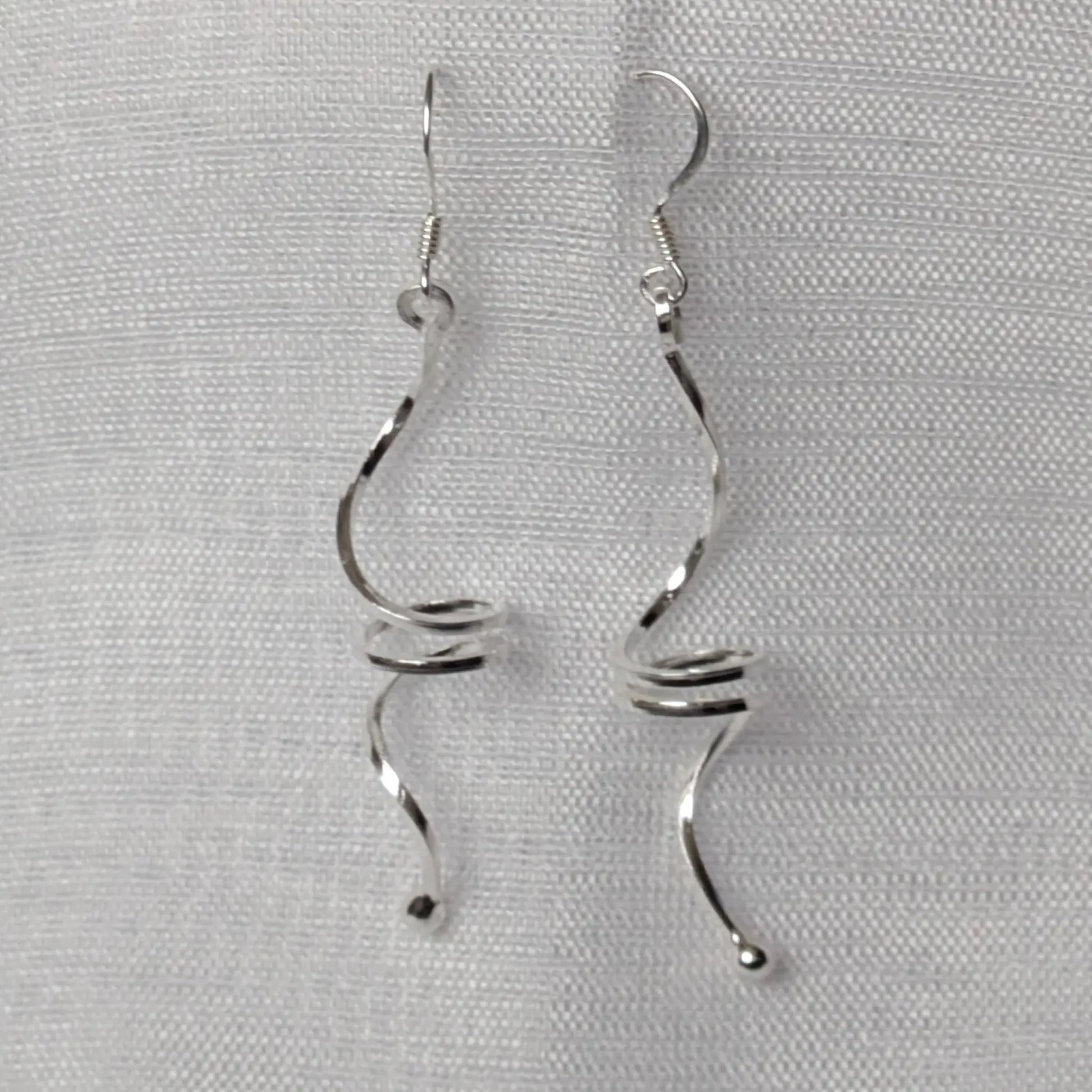 Frontalansicht der langen, geschwungenen Wellen-Ohrringe aus Sterling Silber.