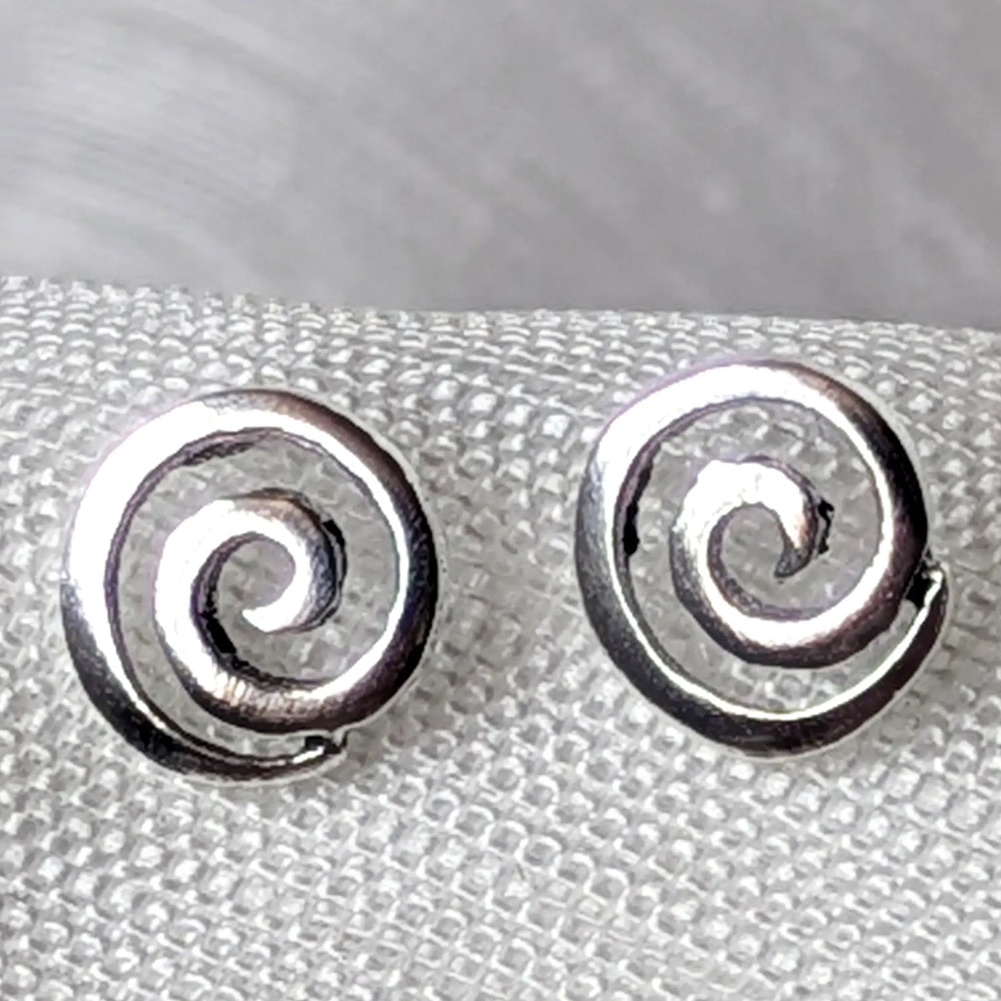 Nahaufnahme Ohrstecker Spirale aus glänzendem 925 Sterling Silber mit feinem Wirbel-Muster