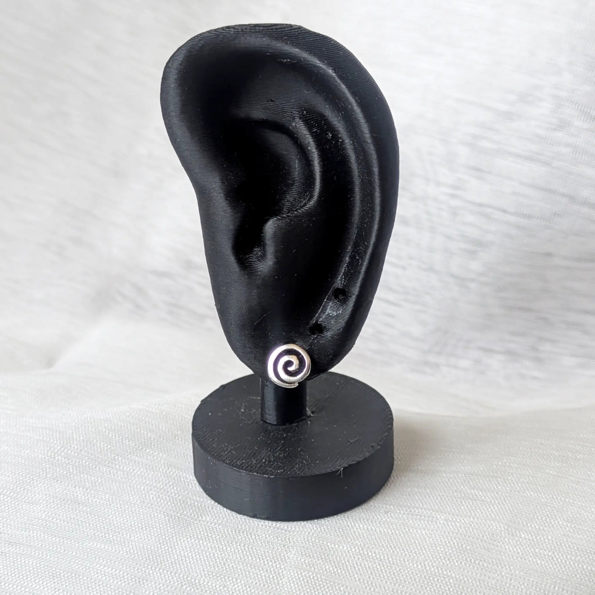 Kleine Spirale Ohrstecker 925 Silber getragen am schwarzen Display-Ohr zur Größenveranschaulichung