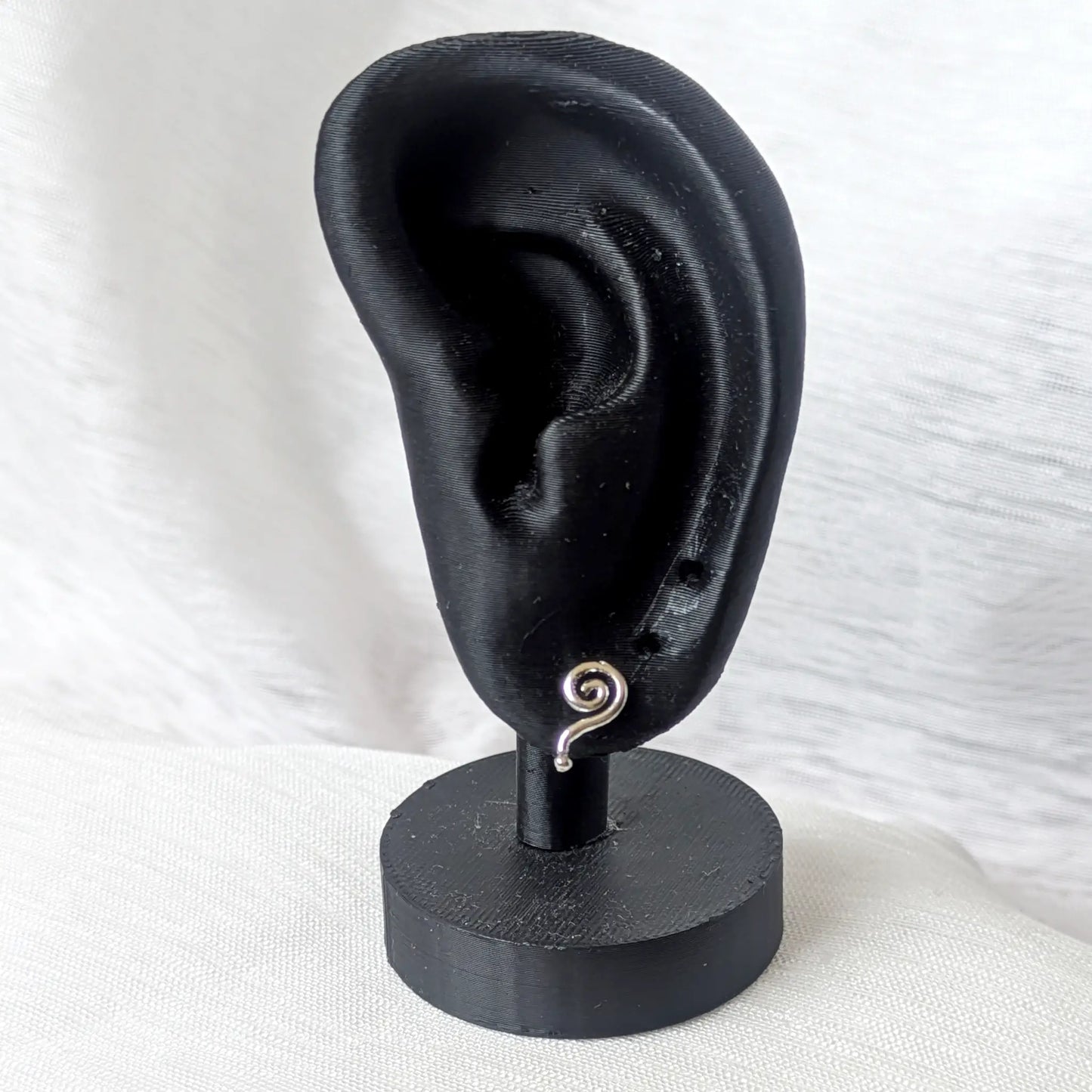 Geschwungener Spirale Ohrstecker 925 Silber am schwarzen Display-Ohr – zeigt den Sitz am Ohrläppchen