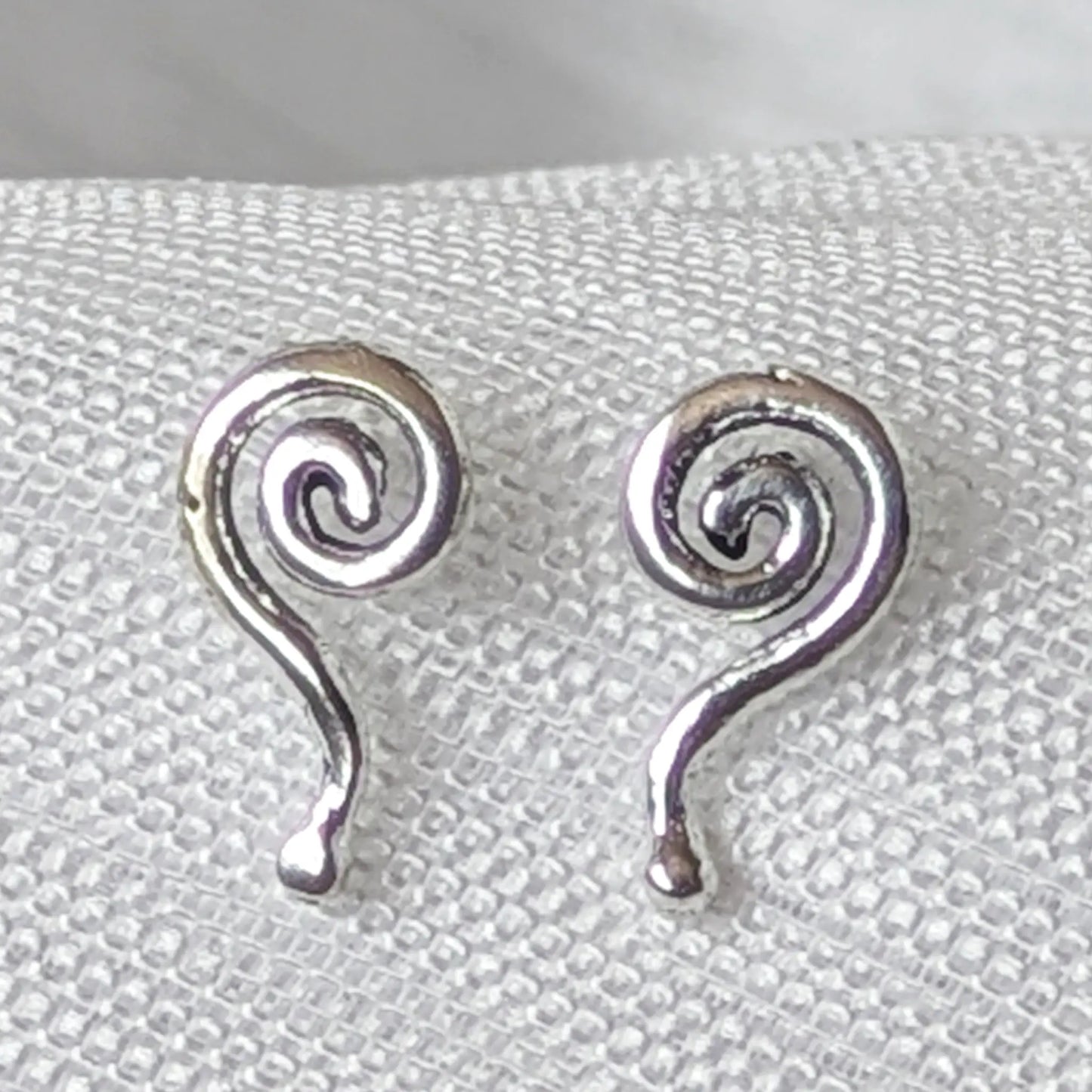 Nahaufnahme Ohrstecker geschwungene Spirale mit Schweif aus glänzendem 925 Sterling Silber