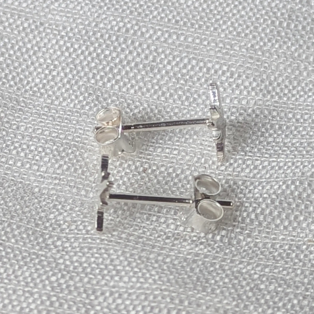 Seitenansicht des Silber-Ohrsteckers im Stern-Design mit sichtbarem Stift zur sicheren Befestigung.