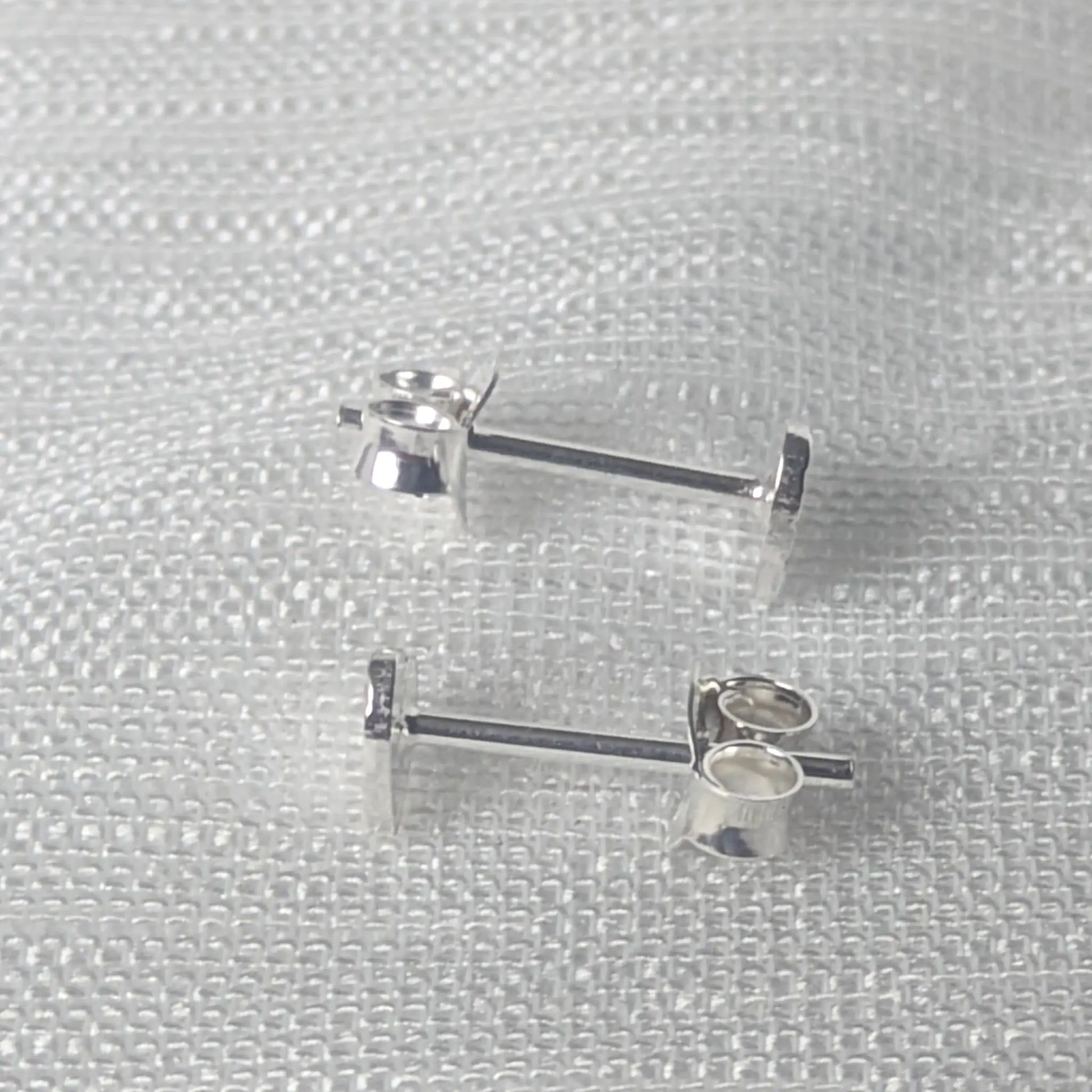 Seitliche Perspektive der gehämmerten Ohrstecker zur Veranschaulichung der flachen, angenehmen Passform auf dem Ohrsteckerstift