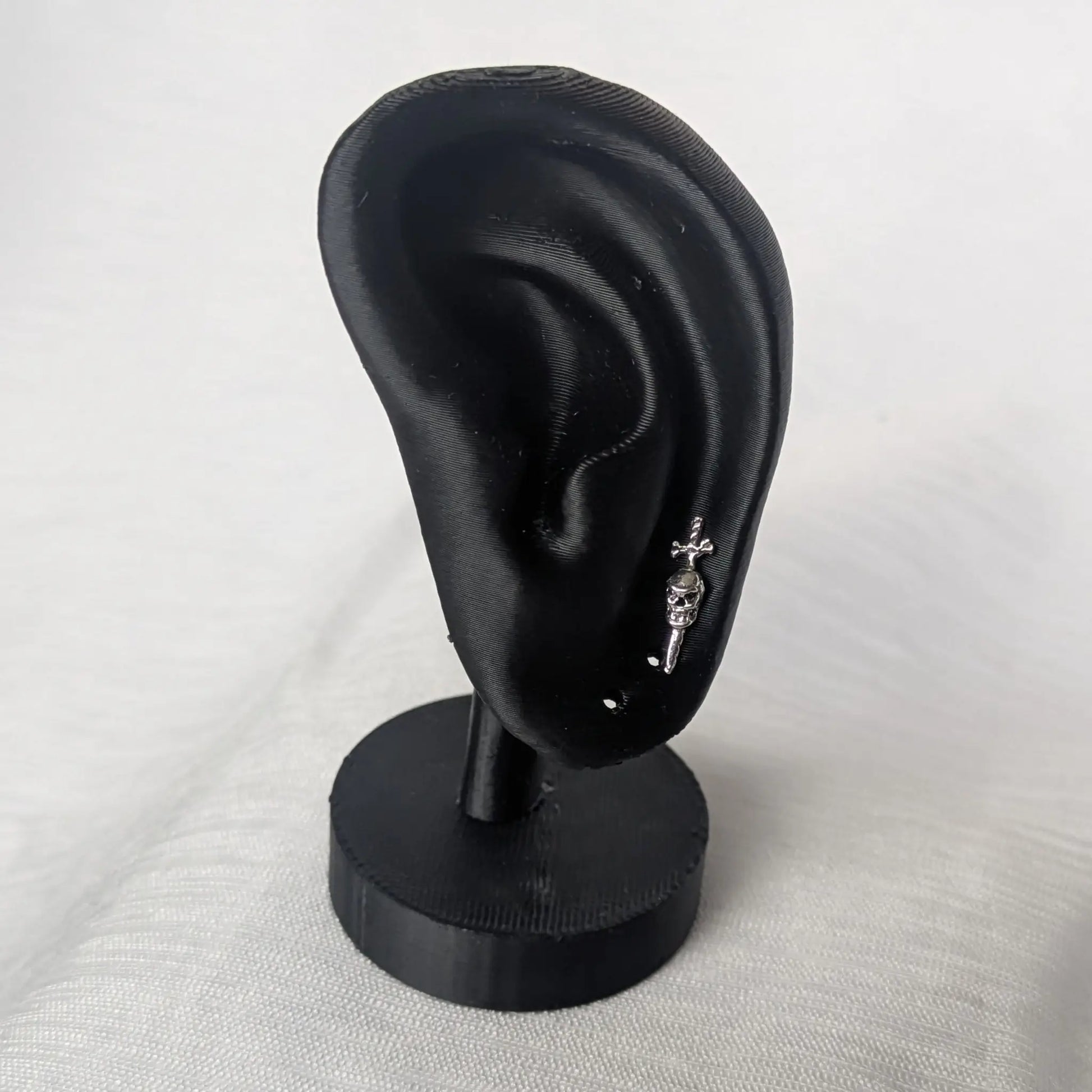 Totenkopf Ohrringe präsentiert an schwarzem Ohr-Display.