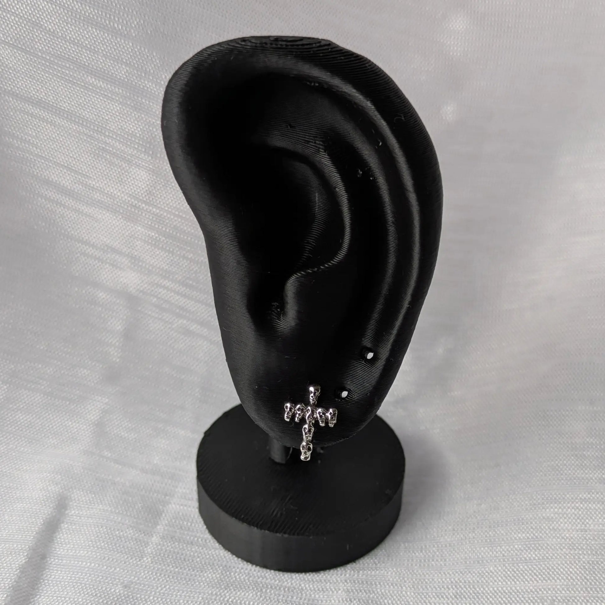 Gothic Totenkopf Kreuz Ohrringe auf schwarzem Schmuck-Display präsentiert.