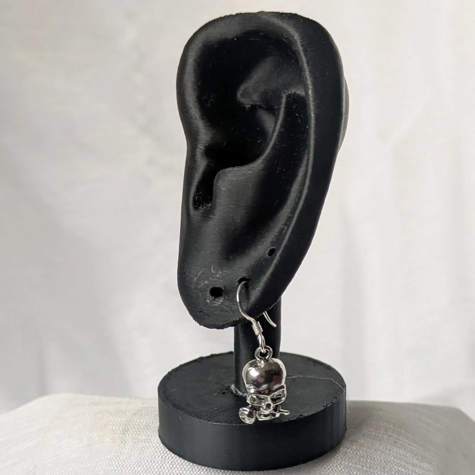 Gothic Totenkopf Ohrringe an schwarzem Schmuckhalter präsentiert.