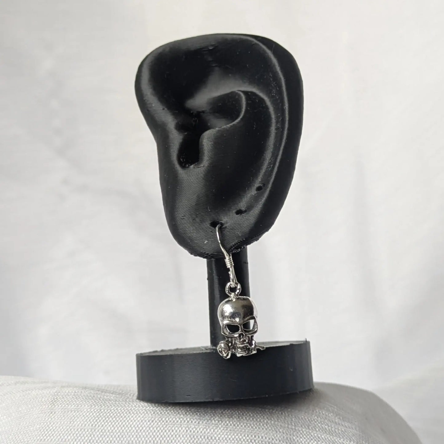 Gothic Totenkopf Ohrringe an schwarzem Ohr-Display präsentiert.