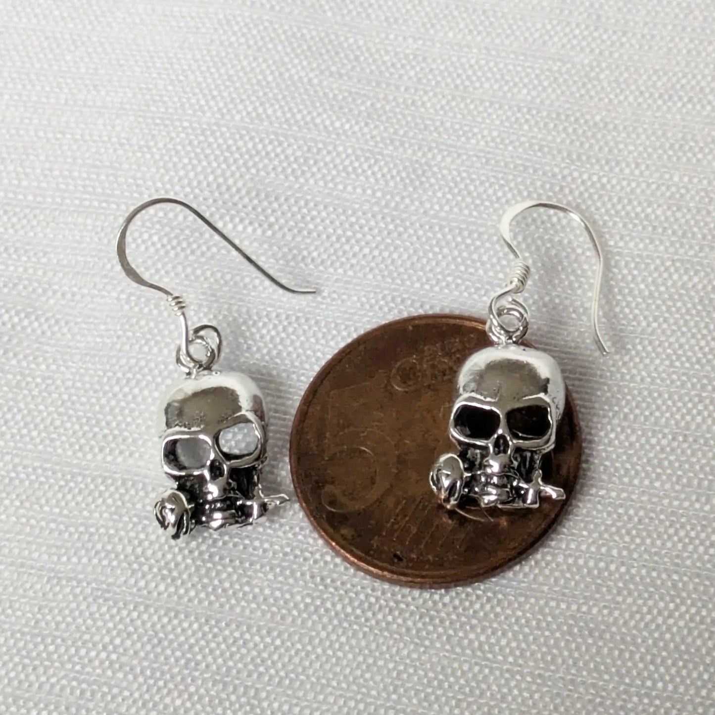 Größenvergleich der silbernen Skull Ohrringe auf einer 5-Cent-Münze.