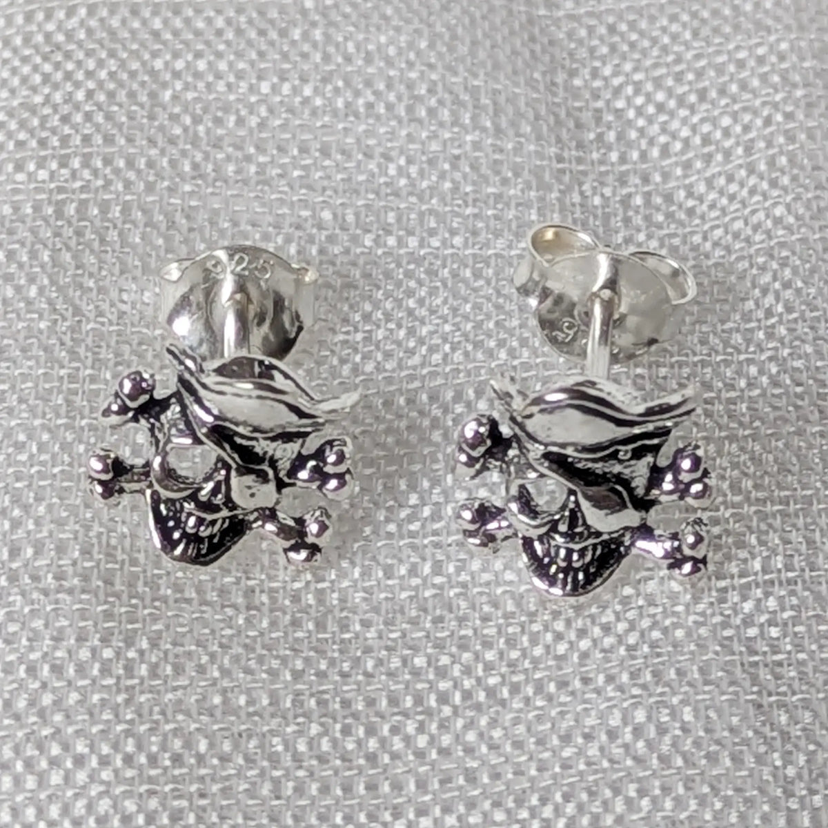 Frontalansicht der massiven 925 Silber Totenkopf Ohrringe im klassischen Jolly Roger Design.