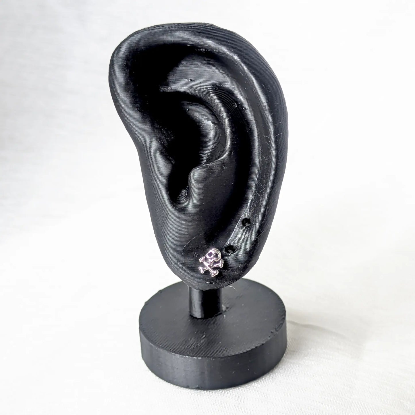 925 Silber Totenkopf Ohrstecker präsentiert an einem schwarzen Ohr-Display.