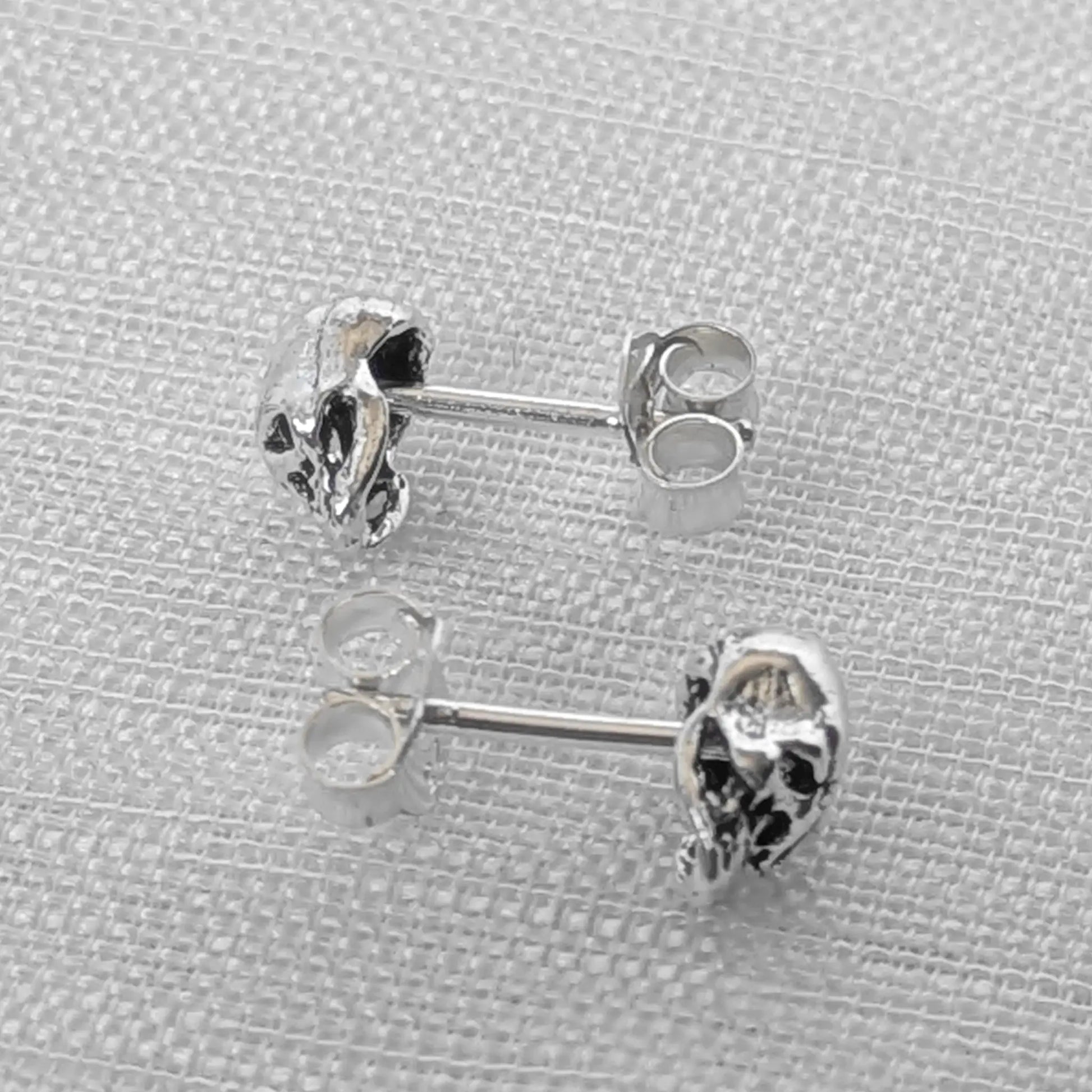 Seitenansicht der Totenkopf Ohrstecker aus Echt-Silber zur Darstellung der plastischen 3D-Form.