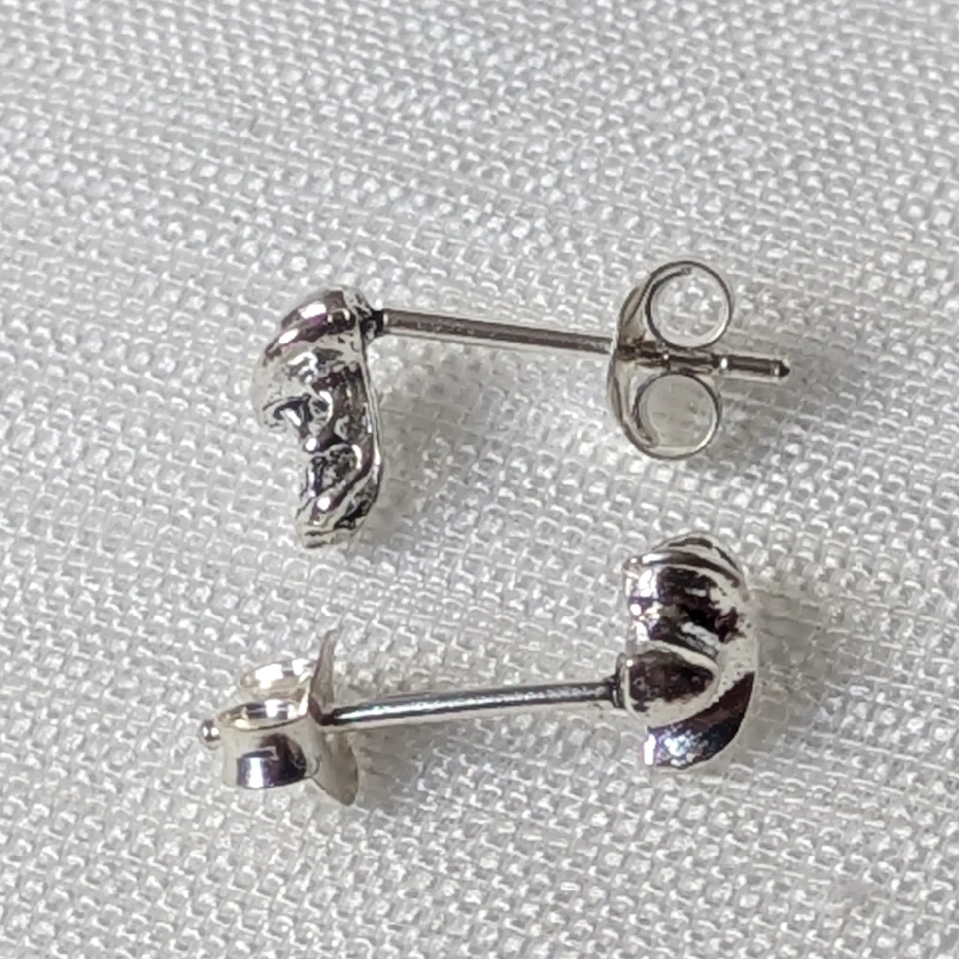 Seitenansicht der 925er Silberohrstecker zeigt das dreidimensionale Design von Totenkopf und Hutkrempe.