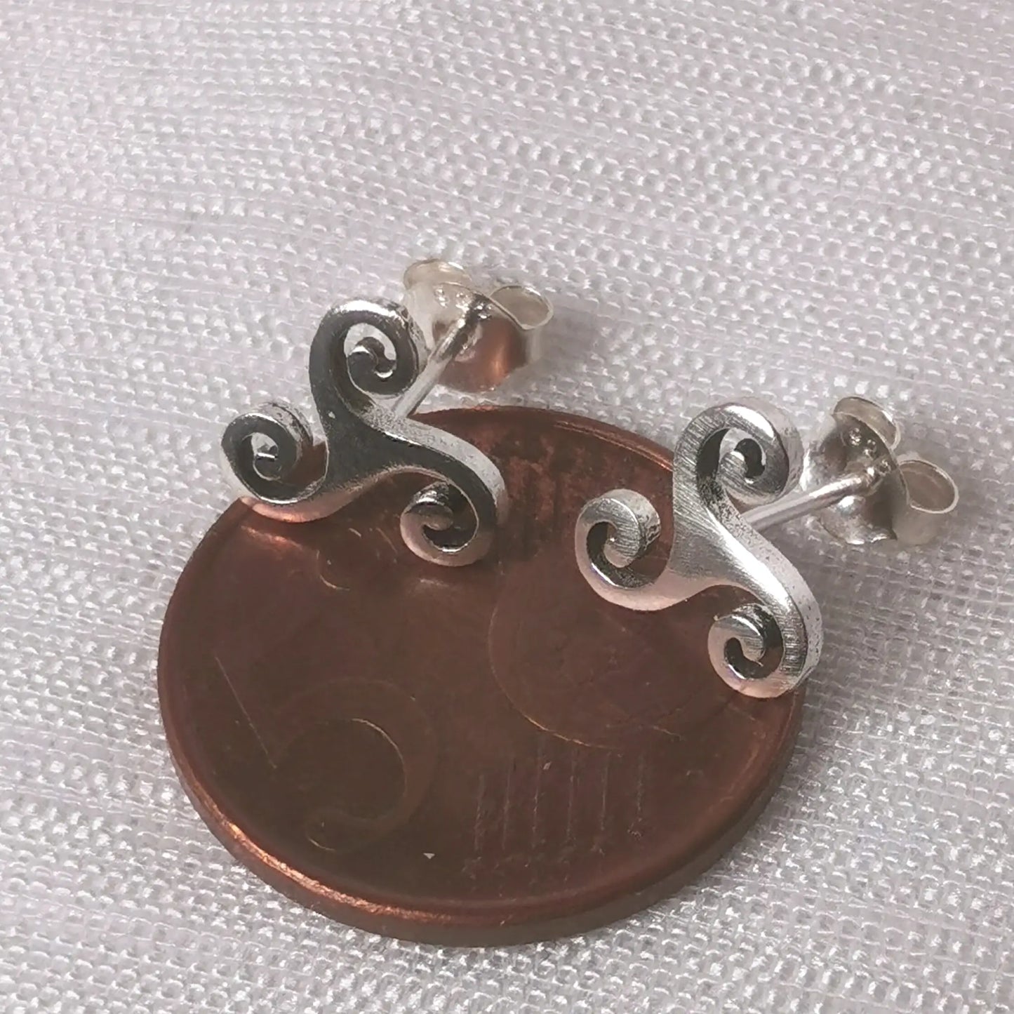 Größenvergleich der keltischen Ohrstecker auf einer 5-Cent-Münze.