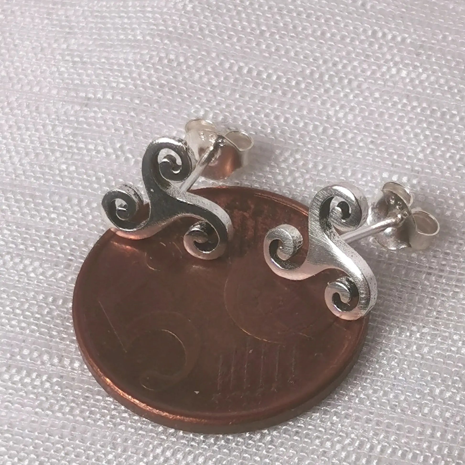 Größenvergleich der keltischen Ohrstecker auf einer 5-Cent-Münze.