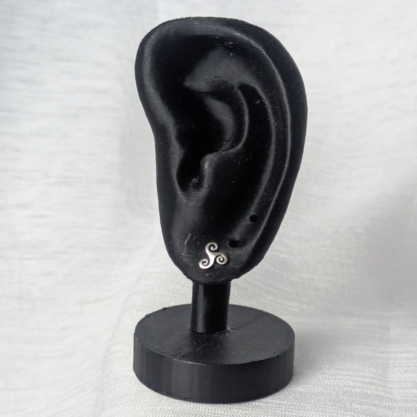 Triskele Silber Ohrstecker präsentiert an einem schwarzen Ohr-Display