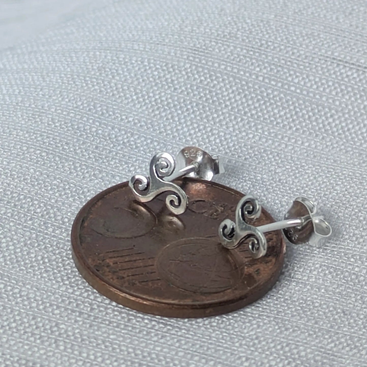 Größenvergleich: Triskele Ohrstecker aus 925 Silber neben einer 5-Cent-Münze