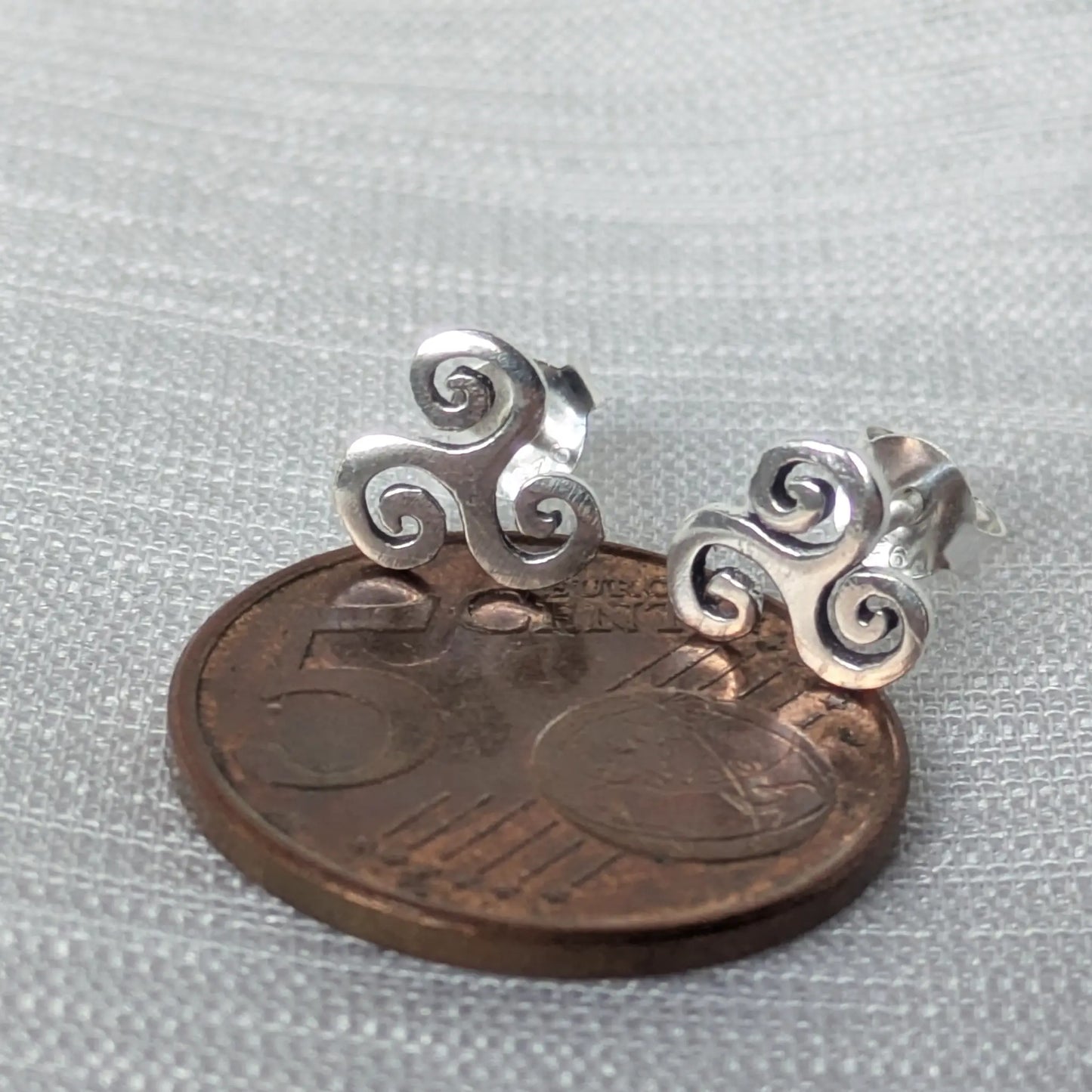 Größenvergleich: Triskele Ohrstecker aus 925 Silber neben einer 5-Cent-Münze