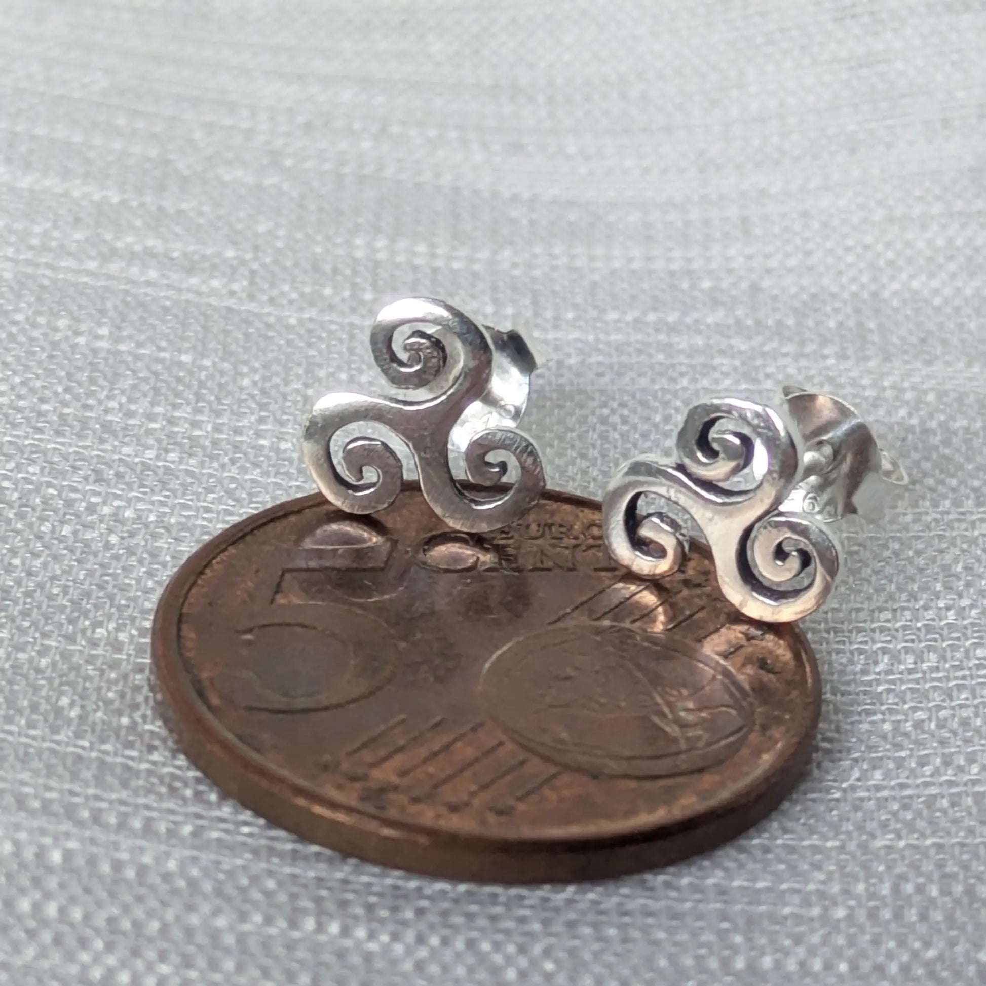 Größenvergleich: Triskele Ohrstecker aus 925 Silber neben einer 5-Cent-Münze