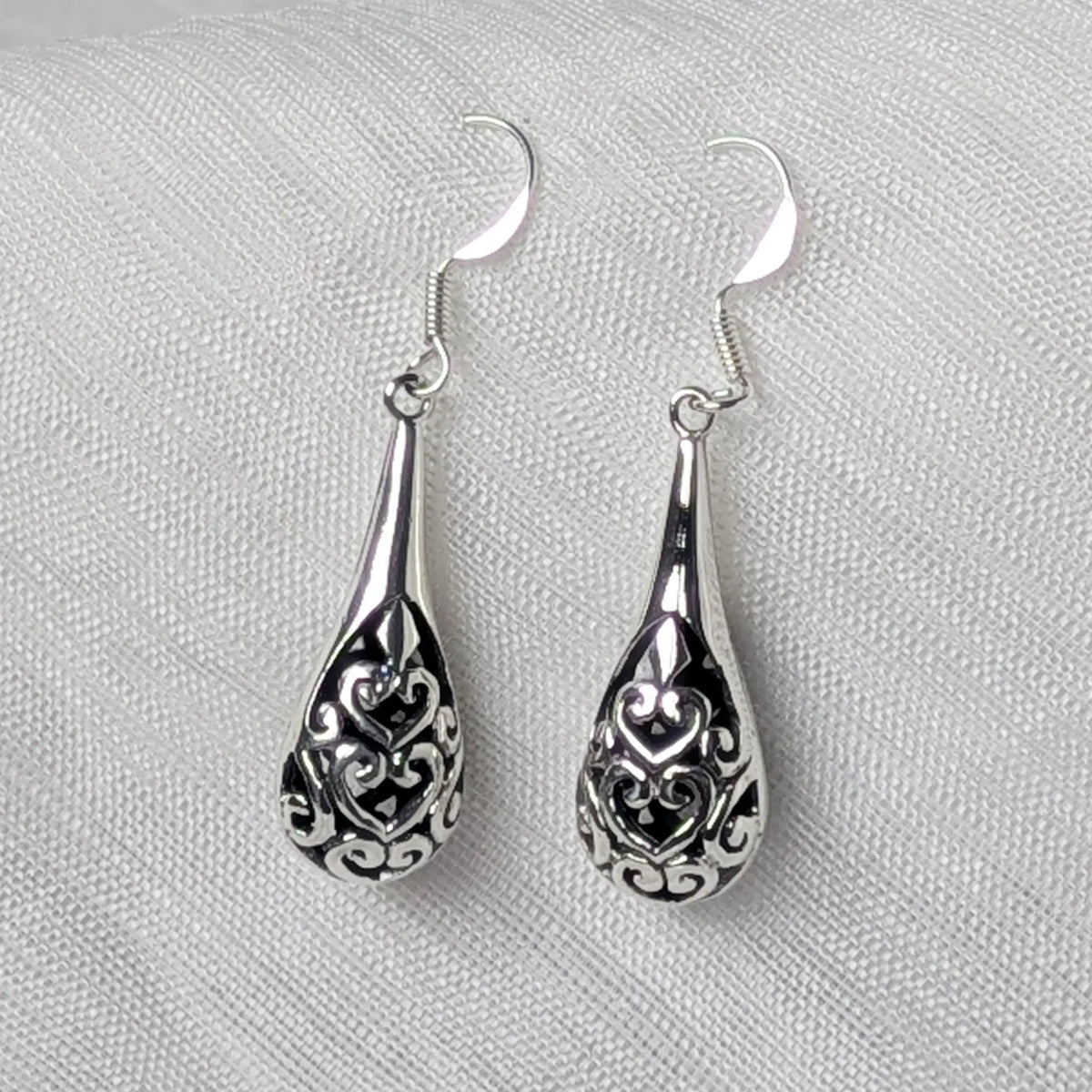 Nahaufnahme filigrane 925 Silber Ohrhänger in Tropfenform mit durchbrochenem Vintage-Muster.