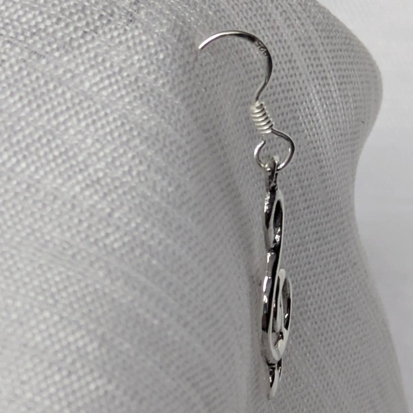 Seitenprofil der geschwungenen Musik-Ohrringe aus Sterling Silber zur Darstellung der Tiefe.
