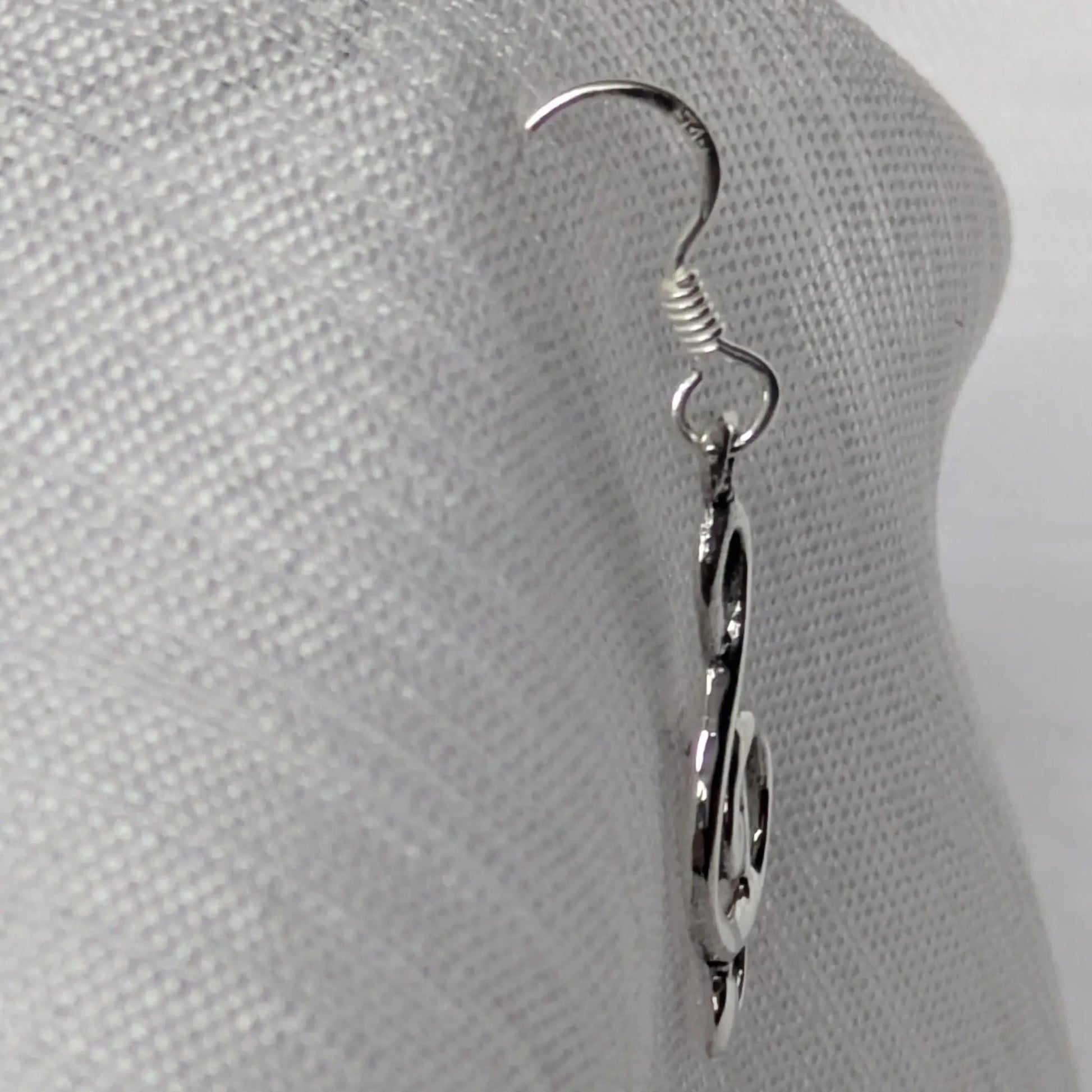 Seitenprofil der geschwungenen Musik-Ohrringe aus Sterling Silber zur Darstellung der Tiefe.