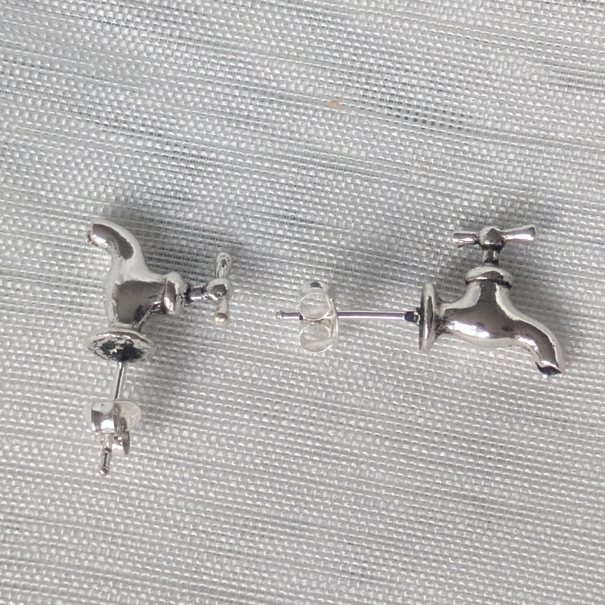 Ein Paar Wasserhahn Ohrstecker aus 925 Sterling Silber als Miniatur-Schmuck abgebildet.