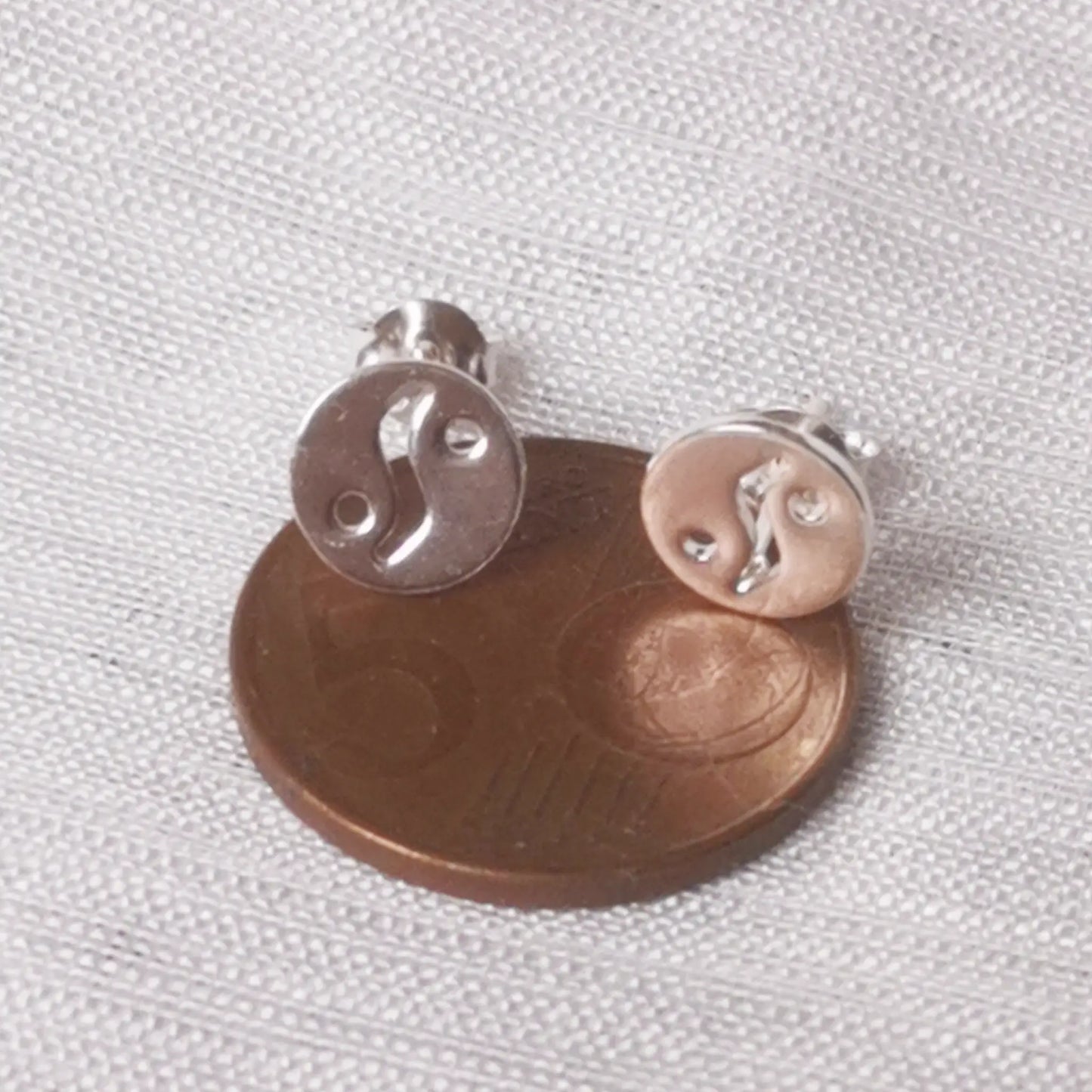 Größenvergleich der kleinen Silber-Ohrstecker direkt neben einer 5-Cent-Münze.