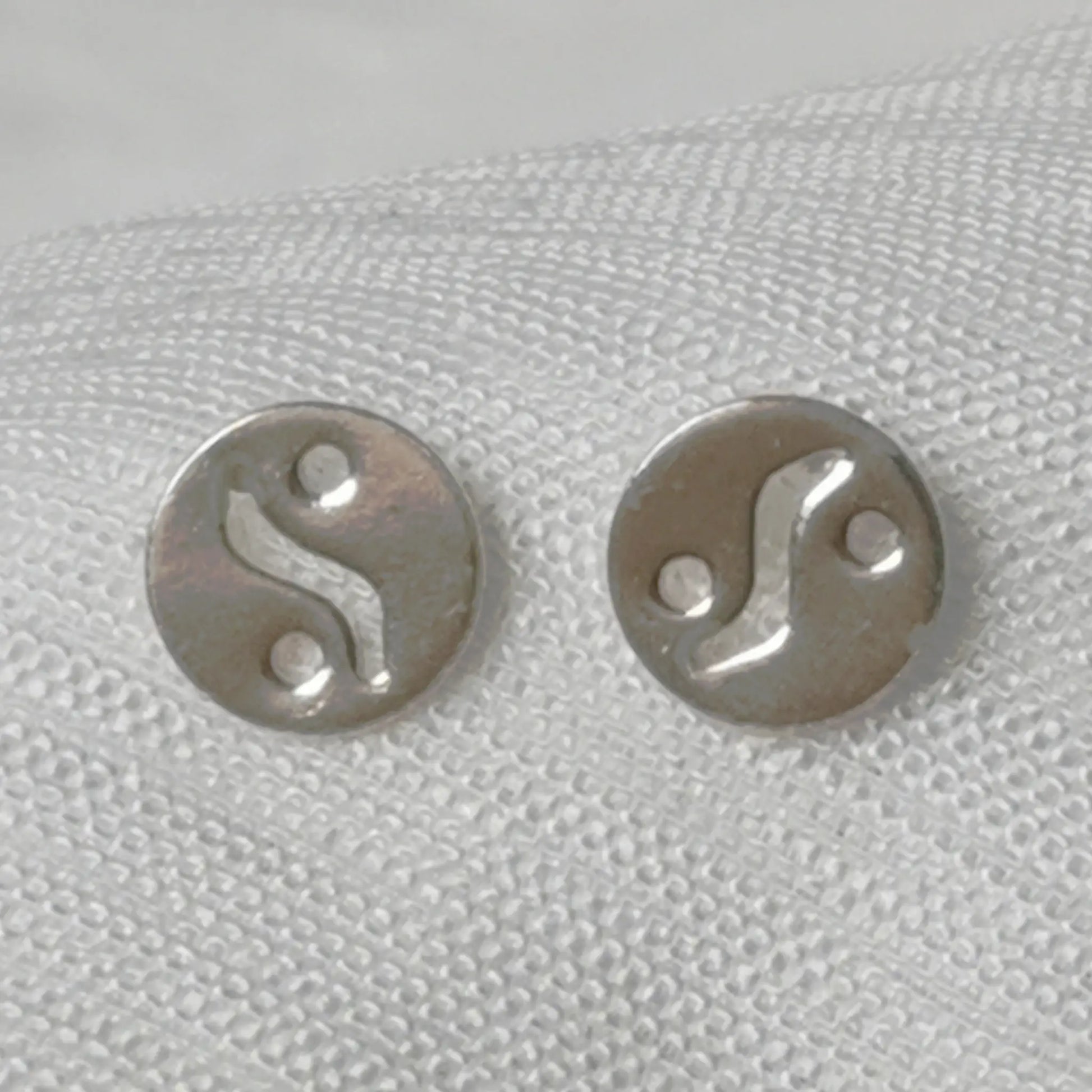 Frontalansicht der runden Yin Yang Ohrringe aus 925 Silber auf weißem Hintergrund.