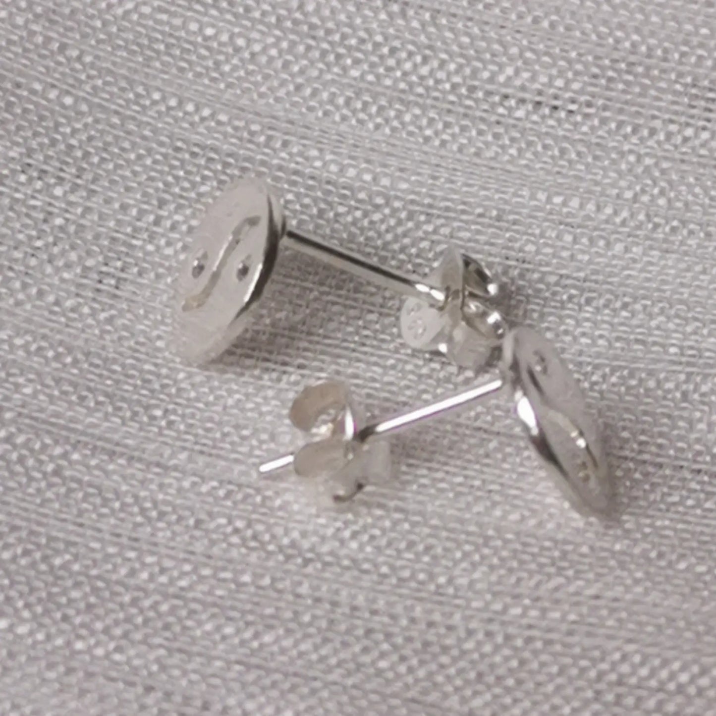 Seitenprofil der flachen silbernen Yin-Yang-Stecker zur Veranschaulichung der Tiefe.
