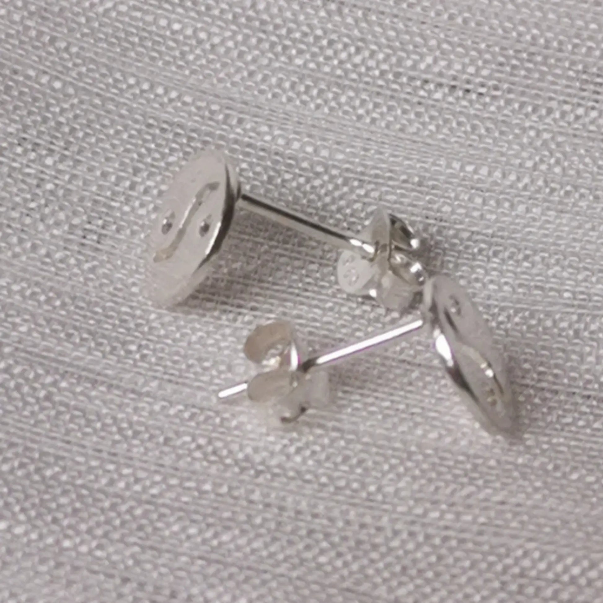 Seitenprofil der flachen silbernen Yin-Yang-Stecker zur Veranschaulichung der Tiefe.