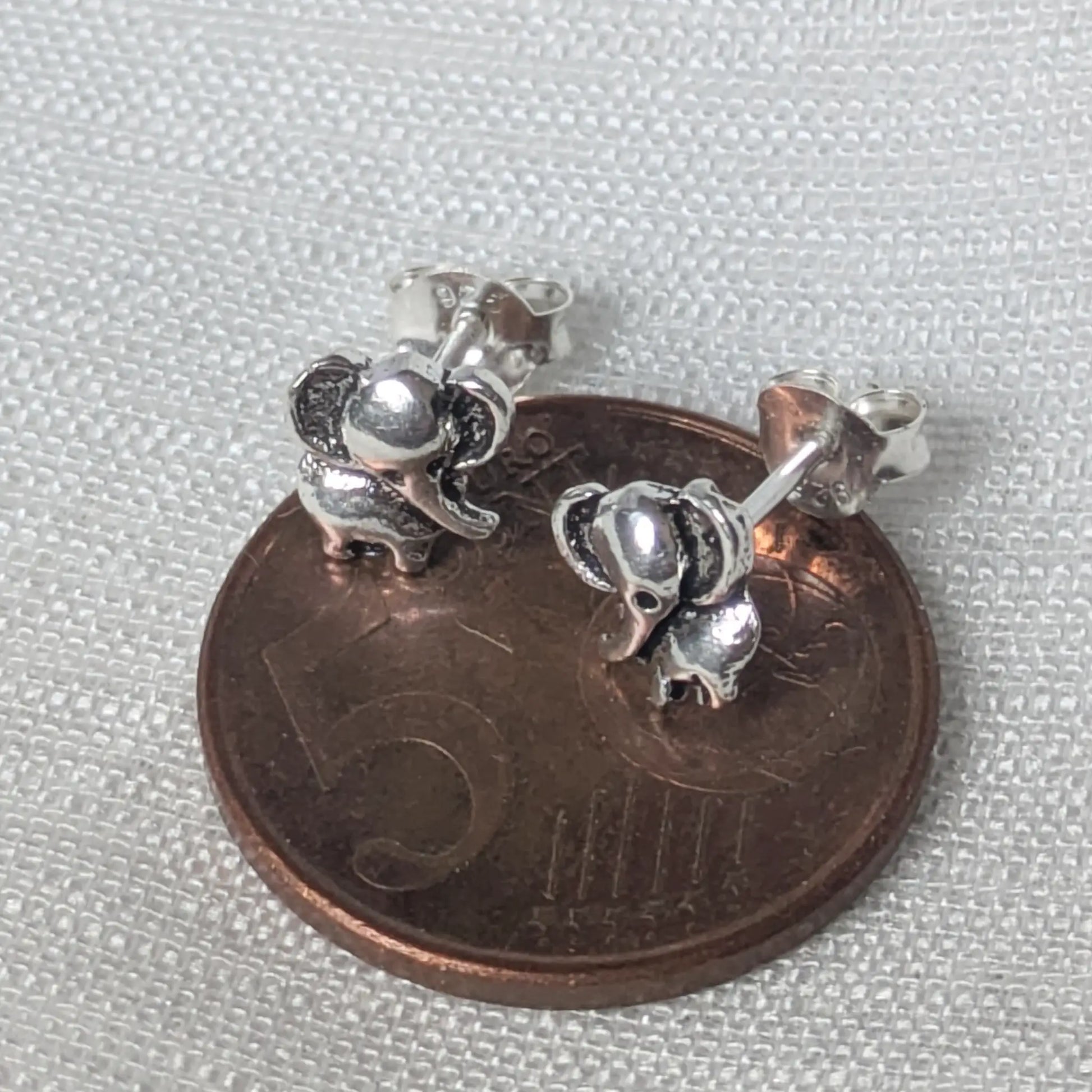 Größenvergleich: Elefanten Ohrstecker aus Silber auf einer 5-Cent-Münze.