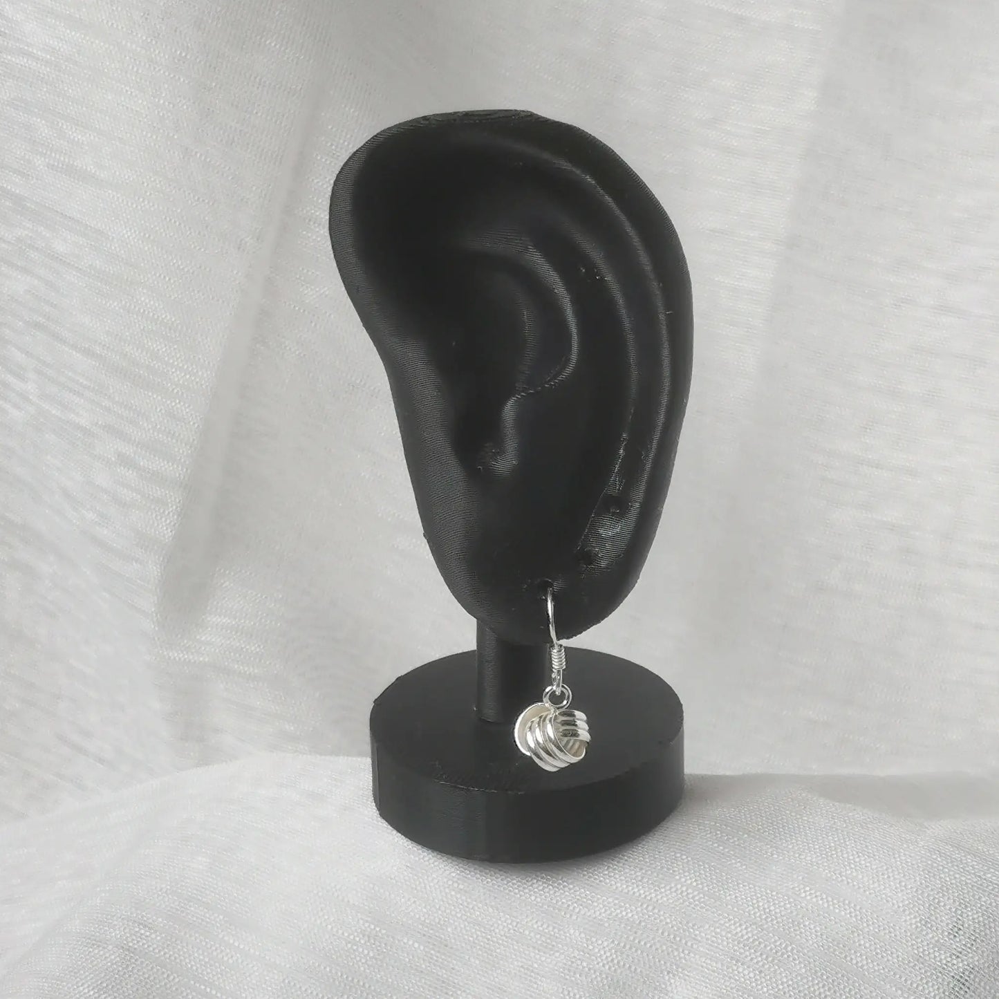 Elegante Hängeohrringe mit Knoten aus 925 Silber am schwarzen Ohr-Displa