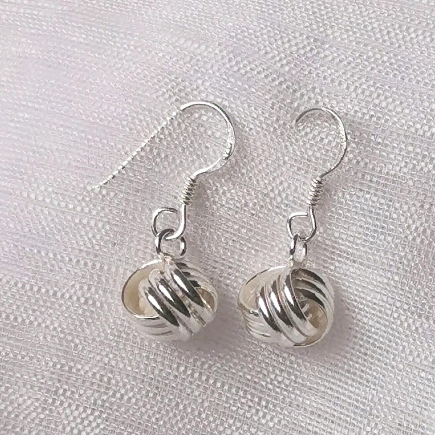 Detailaufnahme der 925 Silber Ohrhänger mit glänzendem Knoten-Motiv