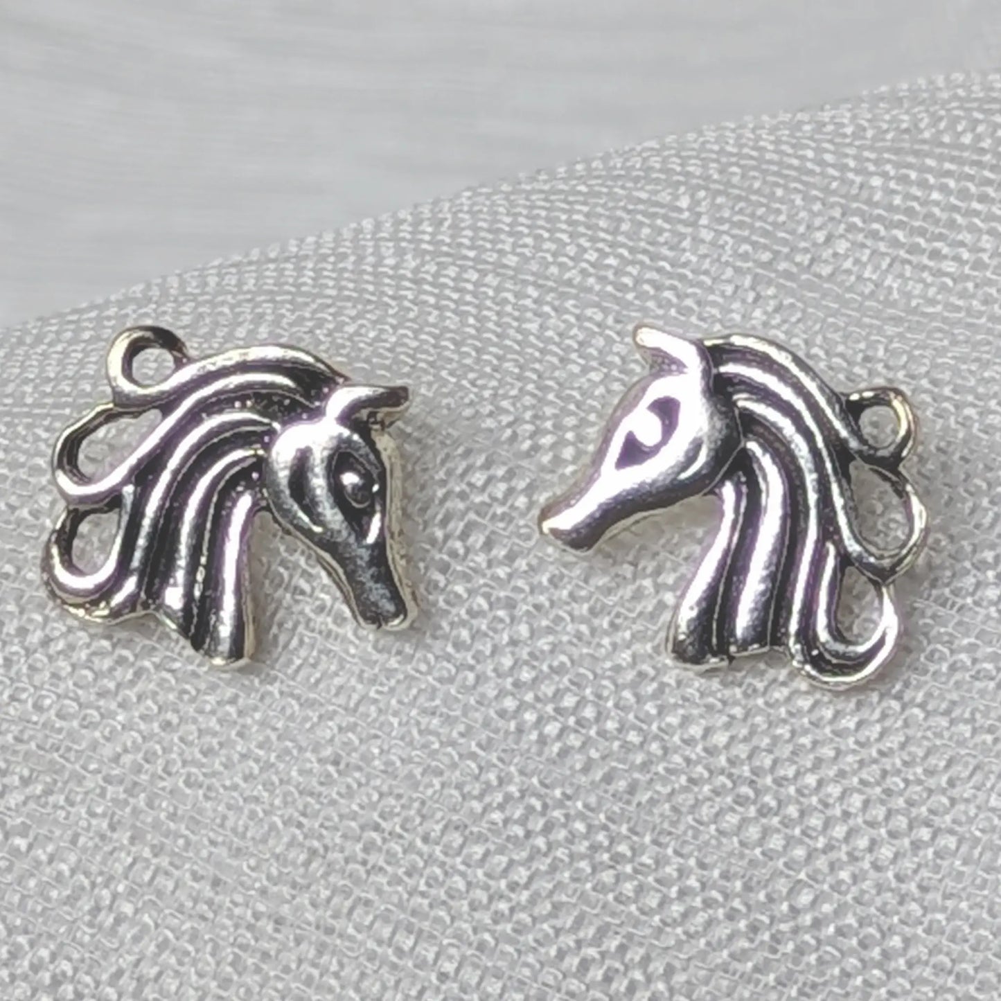 Nahaufnahme von Pferde-Ohrsteckern aus 925 Sterling Silber mit detaillierter Mähne.